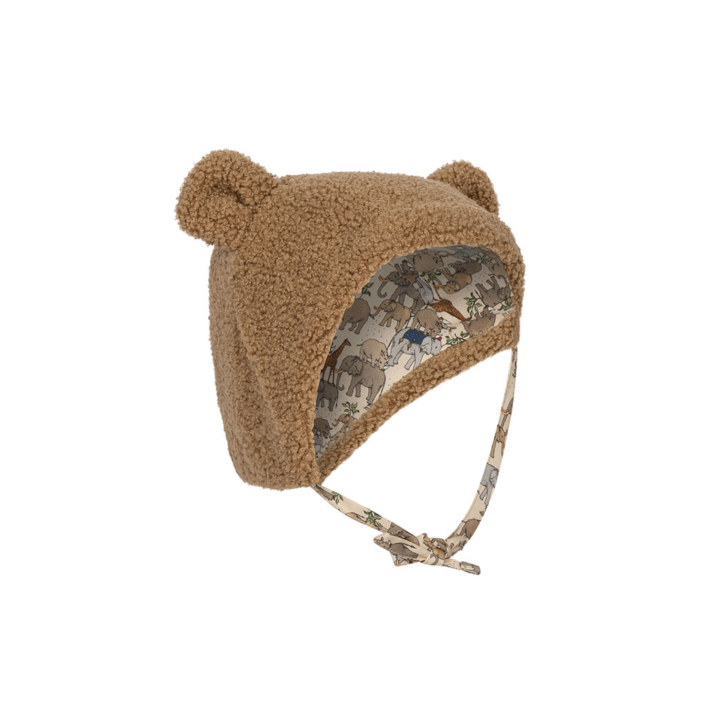 Konges Sløjd Grizz hat Shiitake is een teddy mutsje met oortjes bovenop. Het mutsje valt goed over het hoofdje heen en bedekt ook de oortjes en is te strikken onder de kin