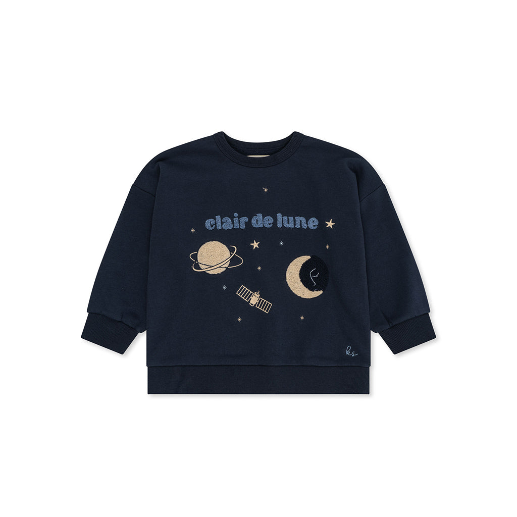 Konges Sløjd Lou Sweatshirt Total Eclipse is een fijne unisex sweater van biologisch katoen. De donkerblauwe trui heeft een geborduurde print met sterren, planeet en maan en de tekst 'clair de Lune' in teddystof. ook de maan en planeet zijn in teddy stof