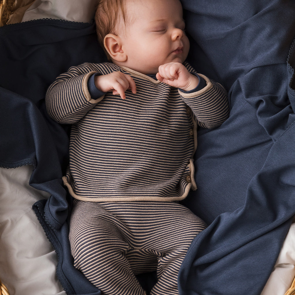Marmar Pira Knit Pant Blue Stripe is een fijn gebreid newborn broekje van katoen en modal. Het Broekje heeft een donkerblauw met beige streepje een brede elastische tailleband in beige en opgerolde boorden.