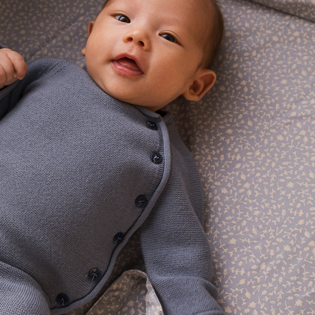 Marmar toll Knit Monsoon Blue is een prachtige newborn trui van 100% merinowol. De wraptop voor baby's wikkel je makkelijk om je baby heen en sluit met hoornen knoopjes. De zomen zijn opgerold voor een speels effect. Merinowol houdt je baby lekker warm in de winter, door zijn warmteregulerende werking. De kleur van de top is een mooie zachte indigo achtige kleur blauw. 