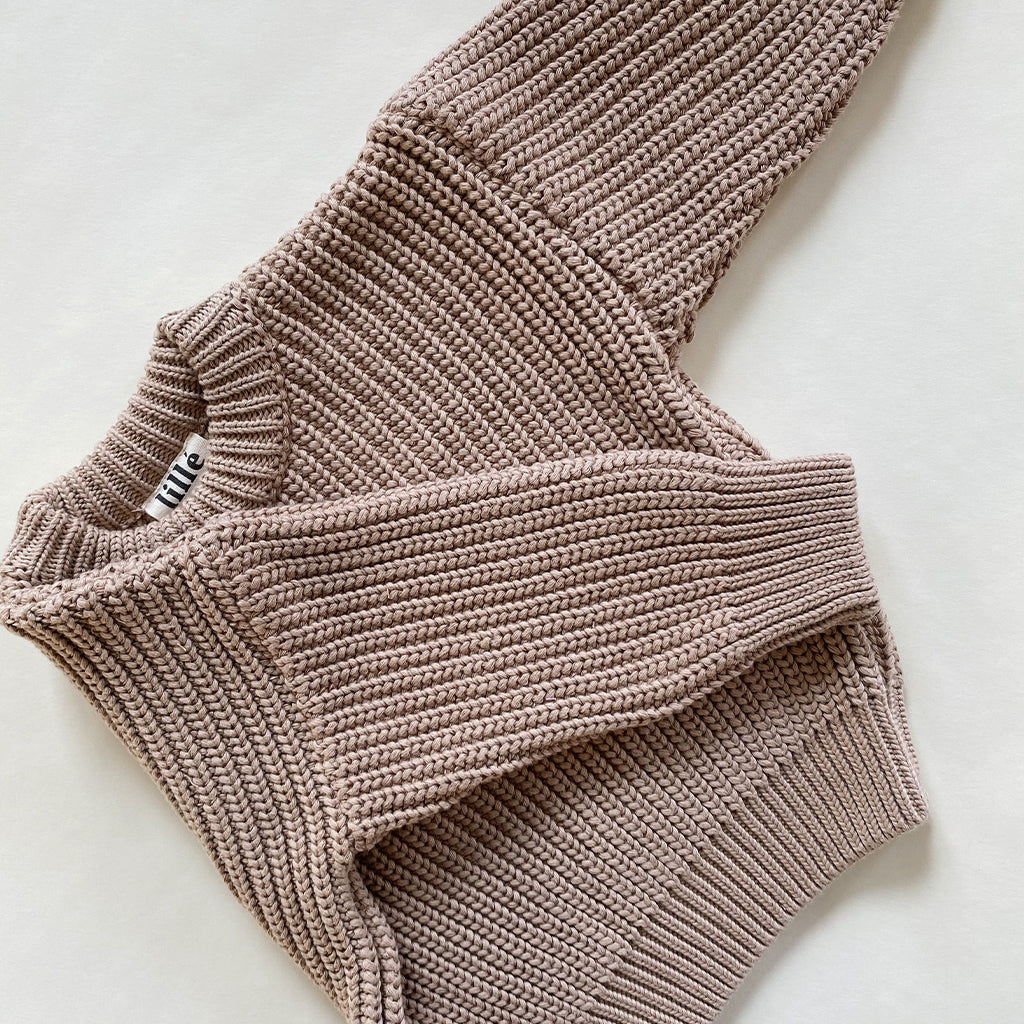 Lillé Chunky Knit Sweater in Dark Beige is een mooie grof gebreide trui voor baby's en kinderen in een mooie neutrale kleur beige. De katoenen trui heeft boorden aan de taille, mouwen en hals en valt op maat, maar heeft een oversized fit. De trui is unisex en leuk voor meisjes en jongens te combineren met rokje, legging of jeans. 
