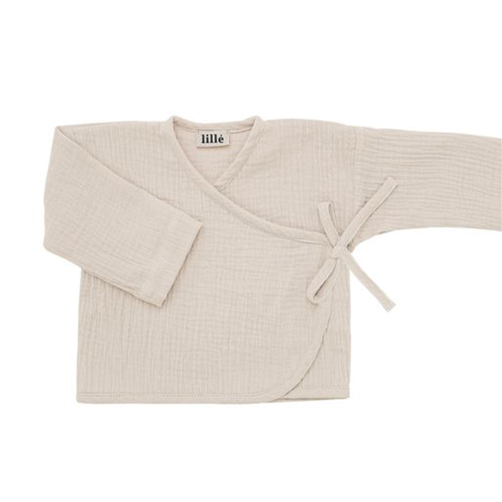 Lillé Muslin kimono top beige is een fijn overslagtruitje voor newborn baby's. Het luchtige mousseline overslagtopje heeft een kimonosluiting met lintje en een drukknoopje aan de binnenkant. De ruime pasvorm maakt het heel comfortabel te dragen en makkelijk met het aankleden.
