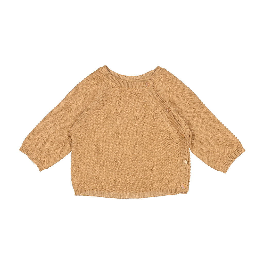 Marmar Top knitwear top cumin is een lichtbruine gebreide baby trui met mooi breipatroon en knoopjes aan de zijkant. De stof heeft een subtiel glansje en daardoor een luxe uitstraling. 